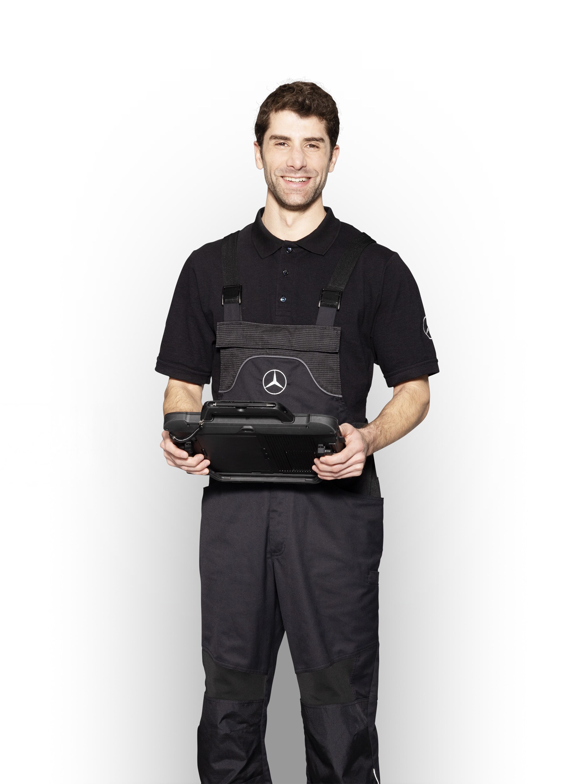 Mercedes-Benz Mechaniker in Arbeitskleidung hält ein Tablet für die Schadensmeldung bereit.