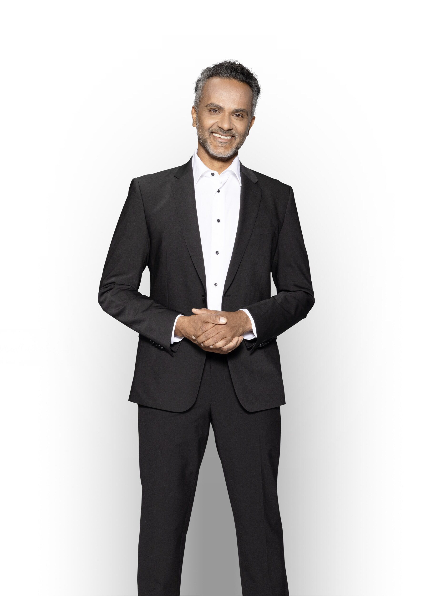 Un responsabile vendite competente, in piedi e sorridente, per garantire l'assistenza del tuo veicolo commerciale elettrico Mercedes-Benz.