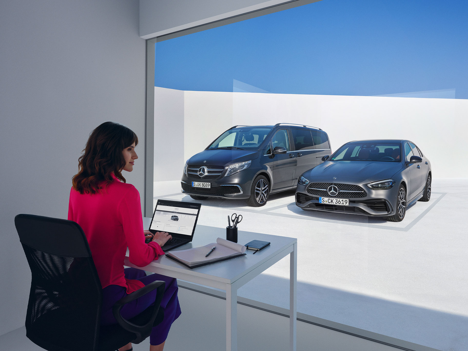 Digitale Extras | Mercedes me Dame mit Laptop vor Mercedes-Benz V-Klasse und C-Klasse.